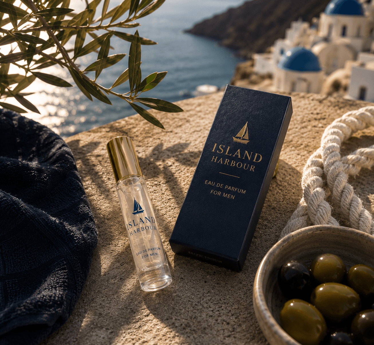 Island Harbour travel spray beside its navy and gold box on a sunlit Mediterranean terrace